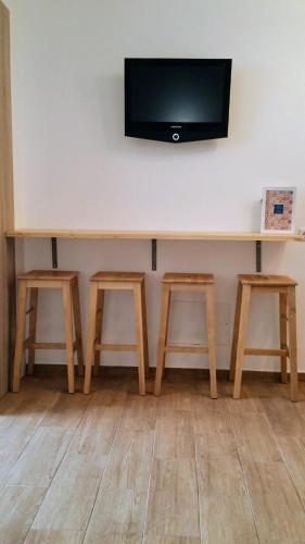 a table with two stools and a television on a wall at D.ANA GUESTHOUSE in Lagos