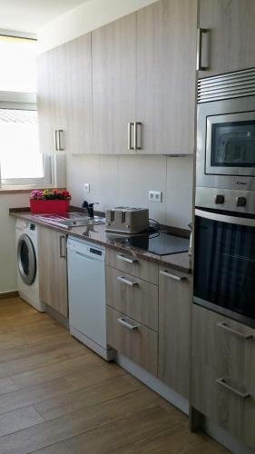 a kitchen with a stove and a microwave at D.ANA GUESTHOUSE in Lagos