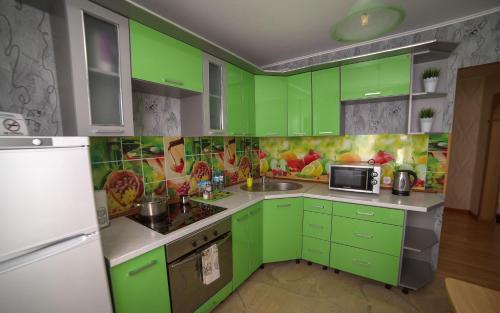 a green kitchen with a sink and a microwave at PaulMarie Apartments on Zaslonova 74 in Soligorsk