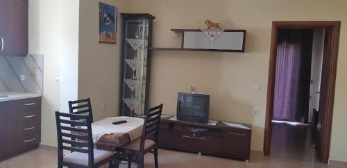 a room with a table and chairs and a television at Vila DINI Ksamil in Ksamil