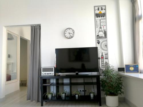 a flat screen tv sitting on a stand in a living room at Vilnius apartment with stained glass in Vilnius