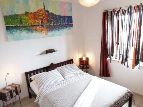 una camera da letto con un letto e un dipinto sul muro di Apartment Lucija 2 a Rovigno (Rovinj)