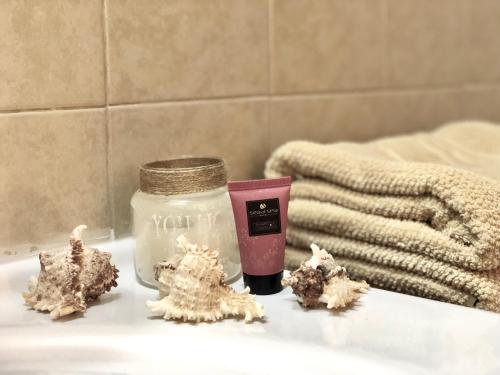 a candle and a jar on a bathroom counter with trees at Stylish Tel Aviv in Tel Aviv