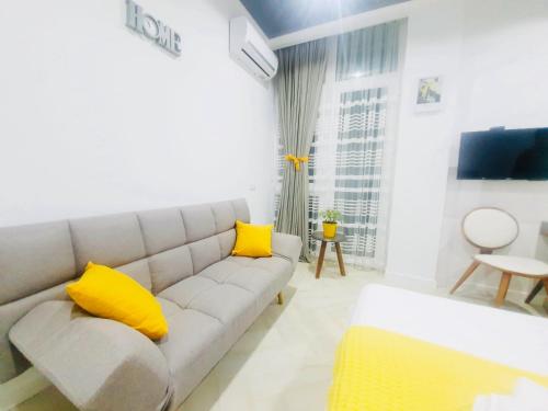- un salon avec un canapé et des oreillers jaunes dans l'établissement Yellow room with sea view, à Makhinjauri