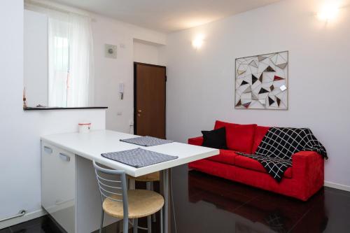 米蘭的住宿－Bilocale Zona Centrale，客厅配有红色的沙发和桌子