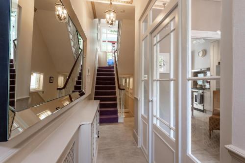 a hallway with a staircase with a glass door at Central London House Zone 1 in London