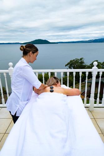 a woman helping a bride in her wedding dress at On The Point - Lake Rotorua in Rotorua
