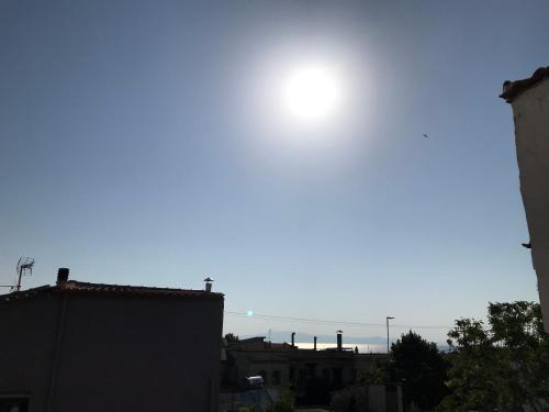 a sun in the sky over roofs of buildings at Modern Apartment Kallithea 2 in Kallithea Halkidikis