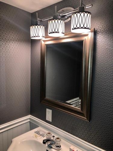 a bathroom with a mirror and a sink at The Village Inn Hotel in Milwaukee