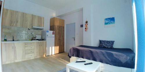 een kleine slaapkamer met een bed en een keuken bij Sea Star Apartments Kallikratia in Nea Kalikratia