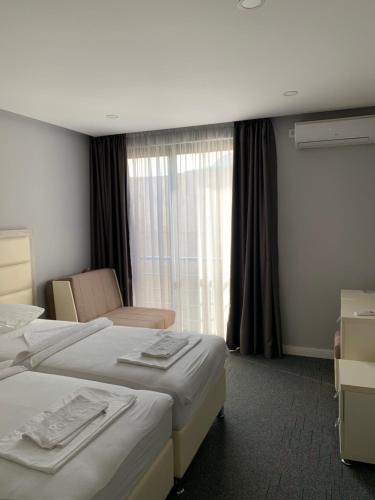 een hotelkamer met 2 bedden en een raam bij Guesthouse Montex in Sutomore