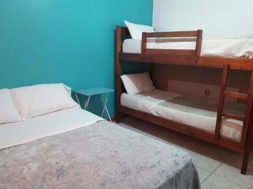 a bedroom with two bunk beds and a blue wall at LA CABAÑA in Termas de Río Hondo