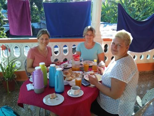 three women sitting at a table eating food at Hostal Vista Hermosa Trinidad in Trinidad