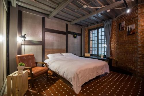 a bedroom with a bed and a chair at The Brick in Tainan
