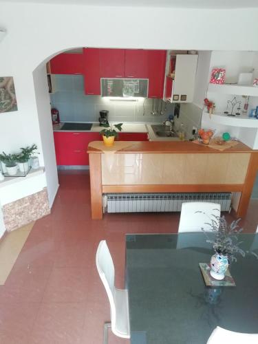 a kitchen with red cabinets and a glass table at Apartments Bosket in Kastav