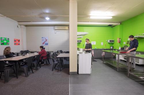 a group of people in a classroom with green walls at Rock Solid Backpackers Rotorua in Rotorua