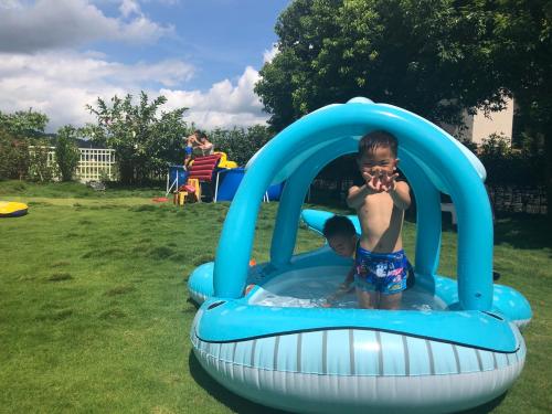 a young boy is playing in an inflatable pool at Emerald Grange in Gongguan