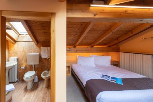 dwa zdjęcia sypialni z łóżkiem i łazienką w obiekcie Chalet Rin Star w Livigno