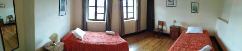 a room with two beds and a door with windows at El Tuco Hotel in Cusco