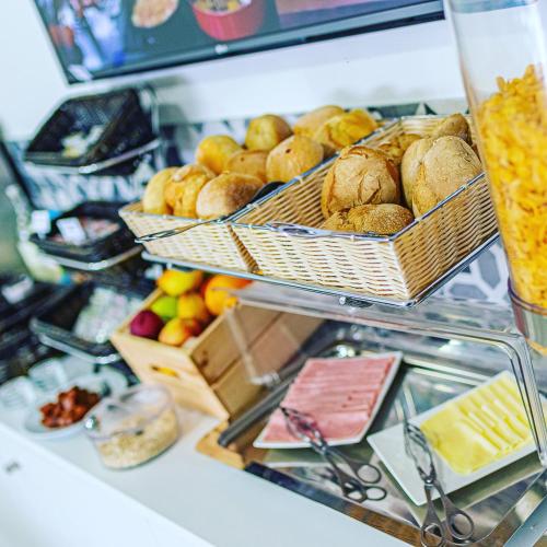 une boulangerie avec des paniers de pain et de fruits sur un comptoir dans l'établissement HI Viseu - Pousada de Juventude, à Viseu