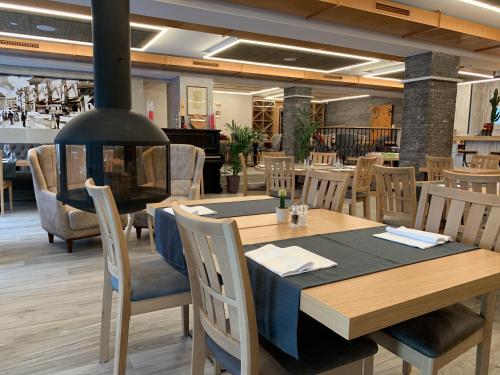 a restaurant with a wooden table and chairs at Hotel Adore in Romanel-sur-Lausanne