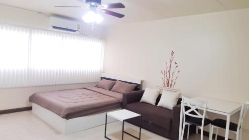 a living room with a couch and a table at Condo C9 IMPACT in Pak Kret
