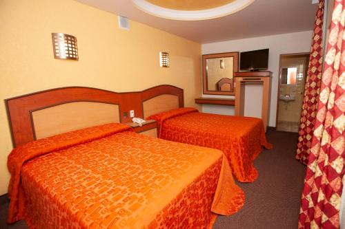 Habitación de hotel con 2 camas con sábanas de color naranja en Hotel Tres Colonias - Sólo Adultos en Ciudad de México