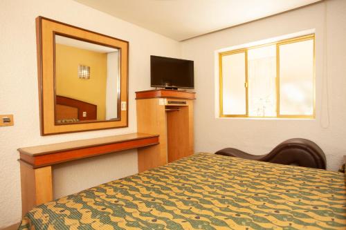 a hotel room with a bed and a mirror at Hotel Tres Colonias - Sólo Adultos in Mexico City