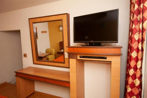 a television sitting on top of a wooden stand in a room at Hotel Tres Colonias - Sólo Adultos in Mexico City