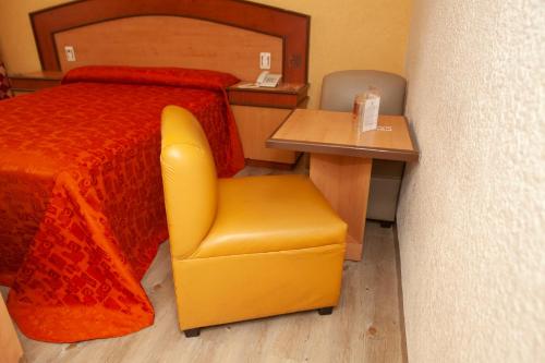 a bedroom with a bed and a chair and a desk at Hotel Tres Colonias - Sólo Adultos in Mexico City