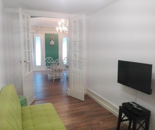 a living room with a couch and a flat screen tv at Casa da Varanda Verde in Vila Real