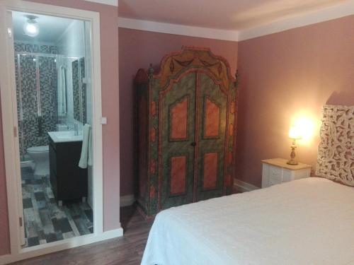 a bedroom with a large wooden door with a bathroom at Casa da Varanda Verde in Vila Real