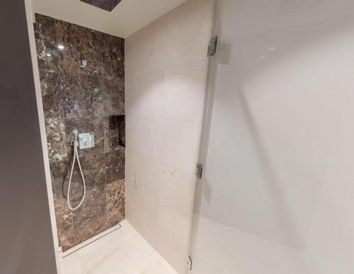 um chuveiro com uma porta de vidro na casa de banho em White Pearl Apartment 2.16 em Timmendorfer Strand