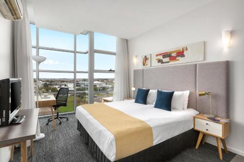 a hotel room with a large bed and a large window at Quest Caroline Springs in Caroline Springs