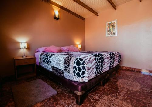 una camera con letto e tavolo con lampada di Diablito Atacama Hostel a San Pedro de Atacama