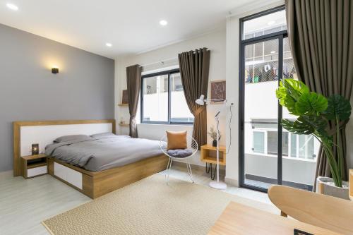 a bedroom with a bed and a desk and a chair at G9 Homestay - Nguyễn Trãi in Ho Chi Minh City