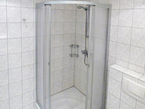 una doccia con porta in vetro in bagno di Obere Wandelbahn 15 Whg. 5 a Wittdün