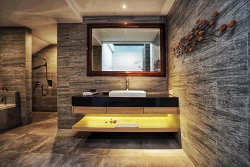a bathroom with a yellow sink and a mirror at The Cakra Hotel in Denpasar
