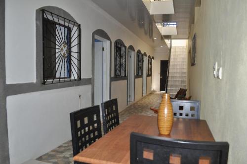 une salle à manger avec une table, des chaises et un vase. dans l'établissement Cuartos Casa Blanca, à León