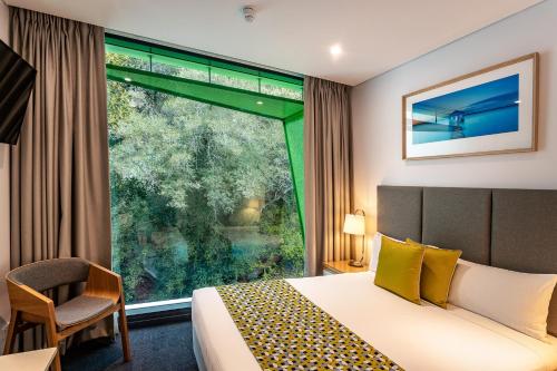 een hotelkamer met een bed en een groot raam bij Quest Mounts Bay Road in Perth