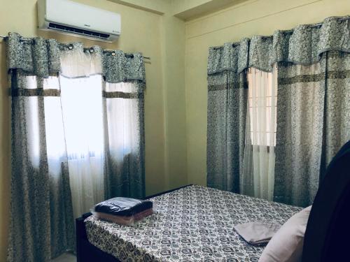 a bedroom with curtains and a bed and a window at Luzville Residences - C5 in Naic