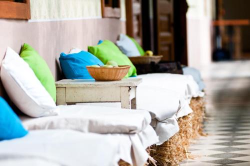 a row of couches with pillows and a table at Jackfall Apartman és Fogadó in Kisjakabfalva