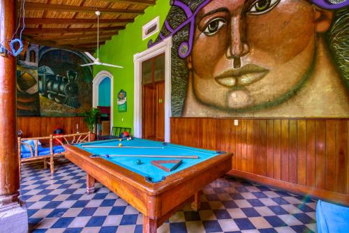 a room with a pool table in front of a mural at Oasis Hostel in Granada