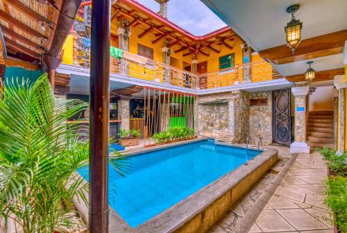 an indoor swimming pool in a house with a ceiling at Oasis Hostel in Granada