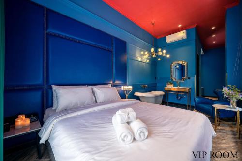 ein blaues Schlafzimmer mit einem Bett mit Handtüchern darauf in der Unterkunft HOTEL le JARDIN SECRET saigon in Ho-Chi-Minh-Stadt