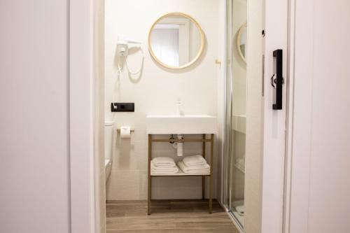 La salle de bains est pourvue d'un lavabo et d'un miroir. dans l'établissement Blanq Comedias, à Valence