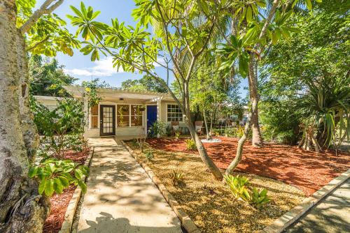 a home with palm trees and a sidewalk at The Blue Door Inn in Fort Lauderdale