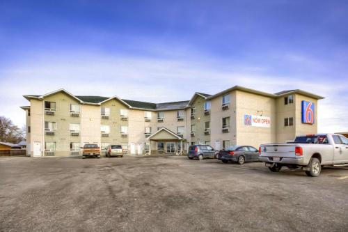 a large hotel with cars parked in a parking lot at Motel 6-Regina, SK in Regina