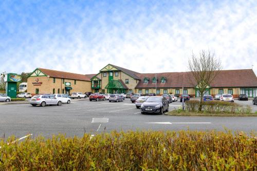 a parking lot with cars parked in front of a building at Best Western Plus Bentley Hotel in Lincoln