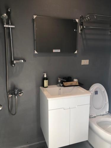 a bathroom with a white sink and a toilet at Chill Chill House in Shimen